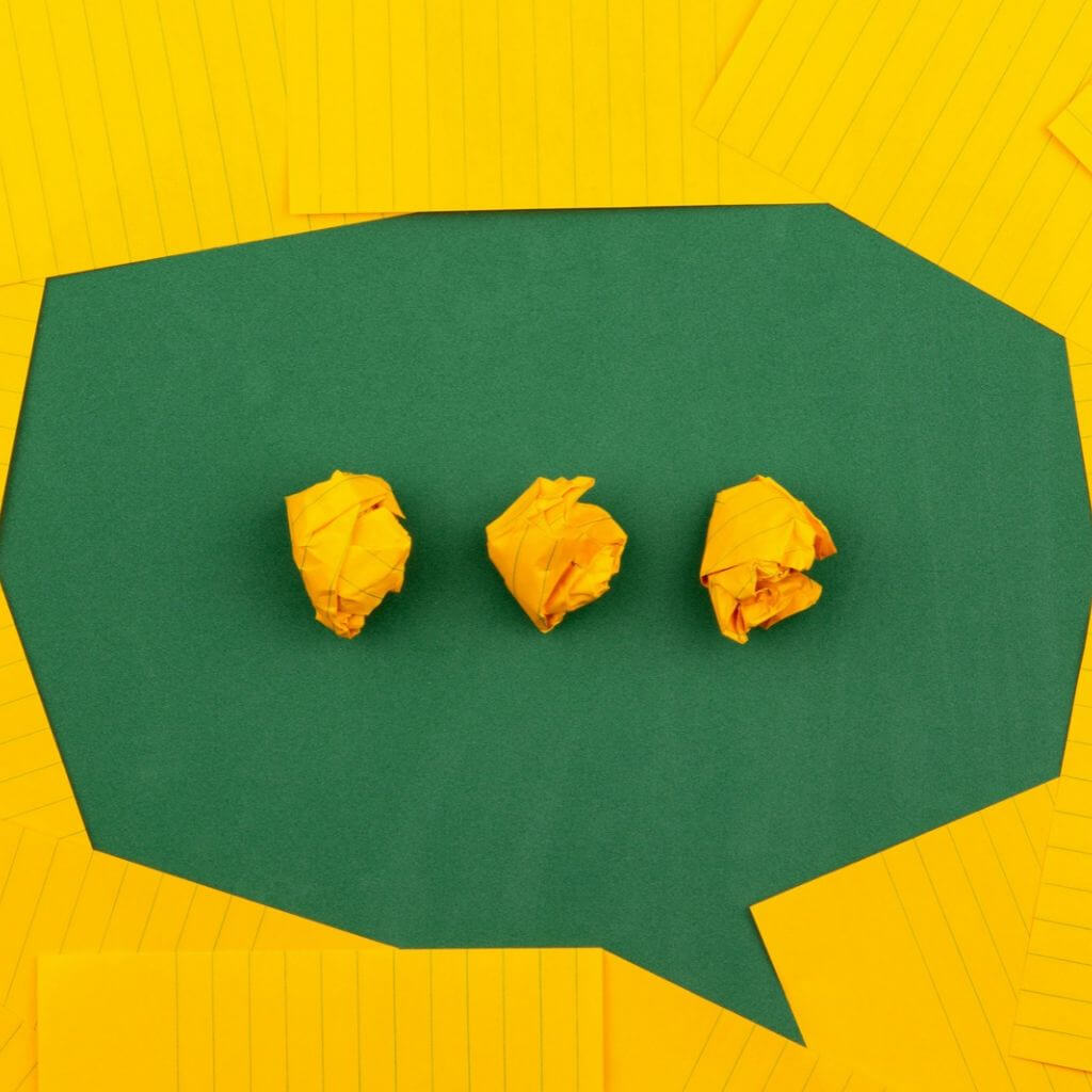 Bulle de discusson verte entourée de feuilles de papier jaune - Valentin Oa écrivain public